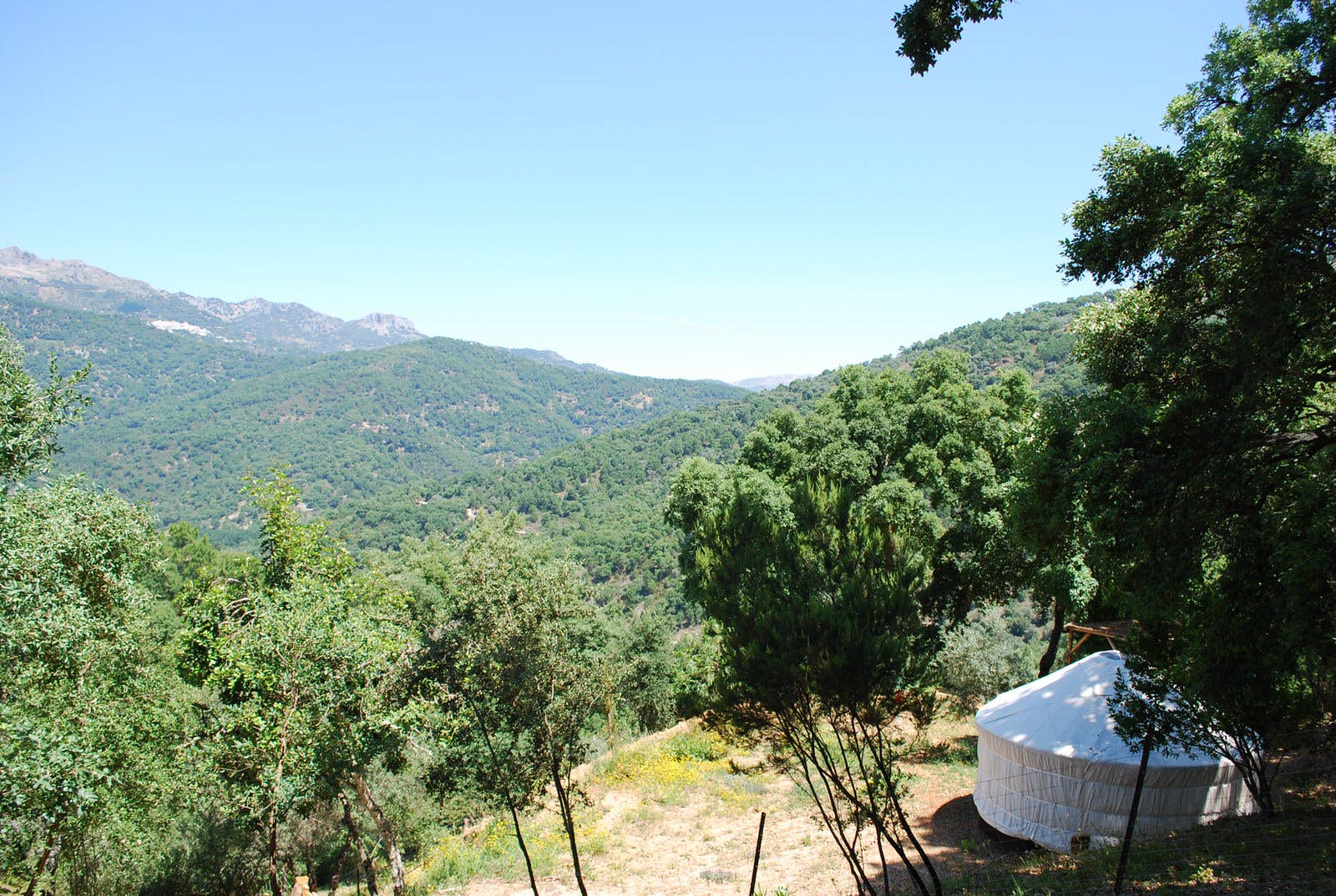Features - andalucia-glamping-586fde25bd96 A white glamping tent looking out over pristine, green rolling hills with nothing else in sight